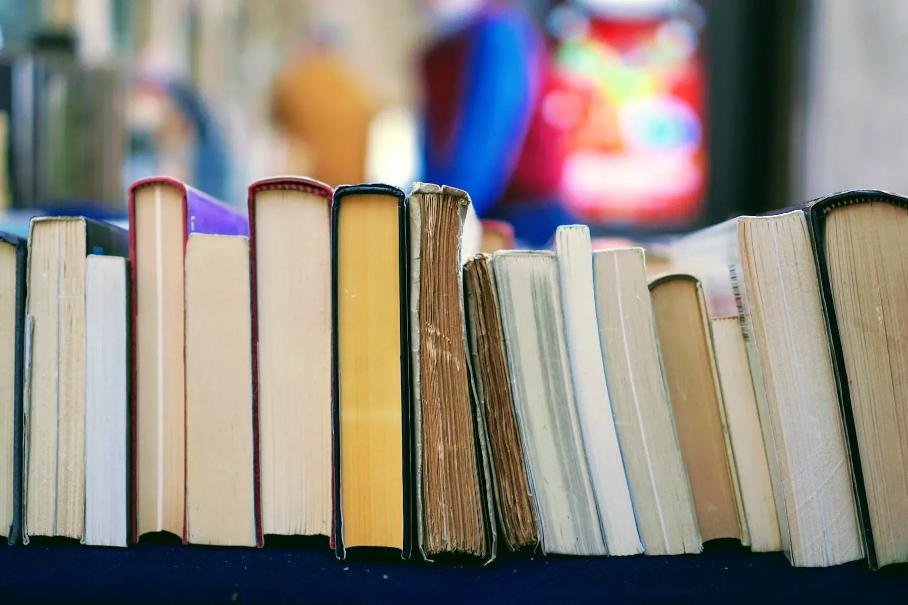 Libros antiguos en estantería, con profundidad de campo y luz cálida
